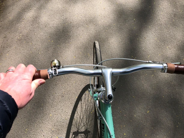 Radfahrer Person radelt auf einem asphaltierten Weg bei sonnigem Wetter, Blick aus der Radfahrer-Perspektive.