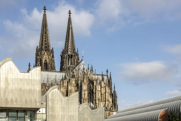 Der Kölner Dom ragt majestätisch über das Museum Ludwig vor klarem Himmel auf.
