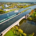 Das Bild zeigt das Wasserstraßenkreuz von oben. Auf dem Mittellandkanal fährt ein Schiff der Mindener Fahrgastschiffahrt.