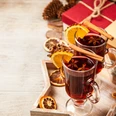 pexels-george-dolgikh-1666061_glühwein.jpg Zwei Gläser Glühwein mit Orangenscheiben und Zimtstangen, umgeben von Gewürzen und Weihnachtsdeko.