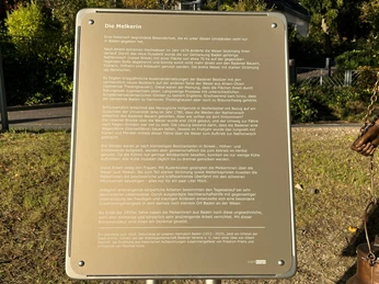 Info-Tafel Die Melkerin Info-Tafel erläutert die Geschichte von Diepholzer Moorsiedlung mit Fokus auf Rolle der Melkerin.