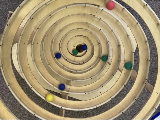 Kugelbahn im Kugelino - Der Kugelbahnspielplatz - Familienurlaub in Leipzig Spiralförmige Kugelbahn mit bunten Holzkugeln im Indoor Spielplatz Kugelino in Leipzig Lindenau.