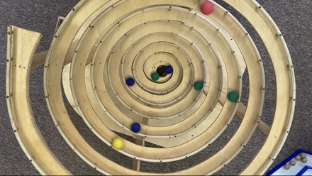 Spiralny tor kulkowy z kolorowymi drewnianymi kulkami na krytym placu zabaw Kugelino w Lipsk Lindenau.