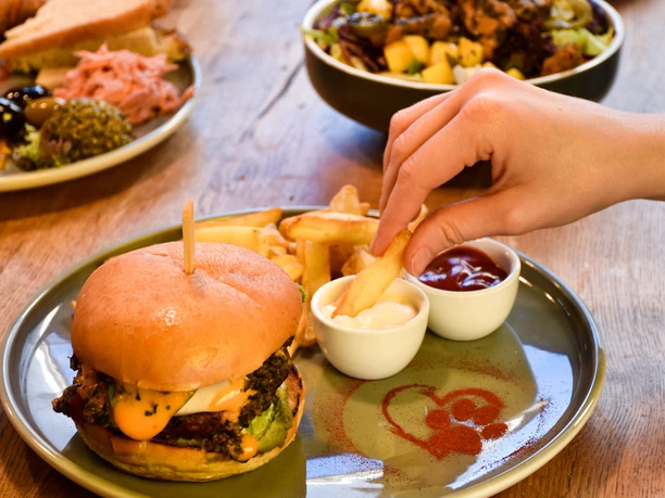 Das Bild zeigt einen veganen Burger mit Pommes.