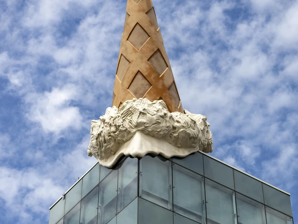 Dropped Cone Eine übergroße, schmelzende Eiswaffel ziert ein modernes Glasgebäude in urbanem Ambiente.