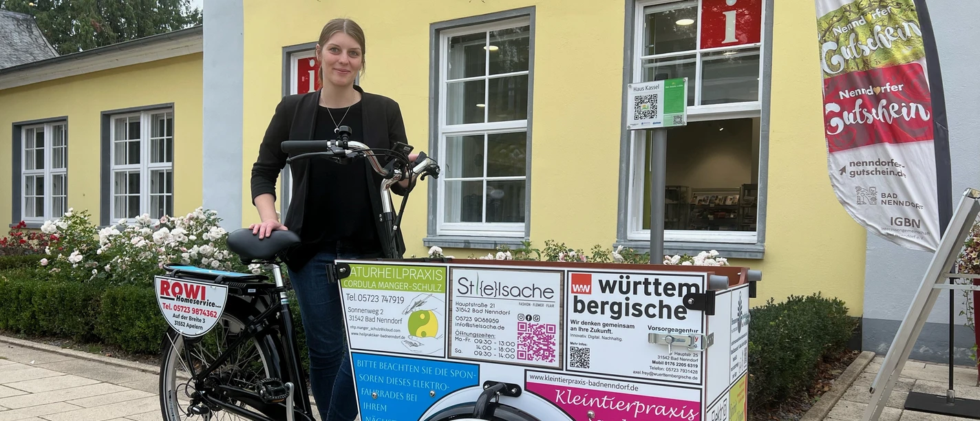 Lastenrad Babboe Ein Lastenrad von Babboe mit Werbeaufdruck vor einem gelben Gebäude in Bad Nenndorf.