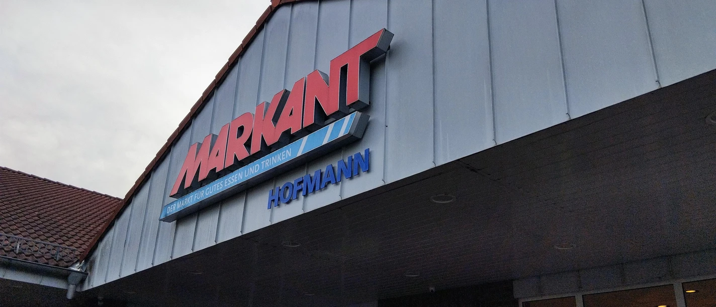 Fassade des Markant Markt Hofmann mit rotem Schriftzug über dem Eingang