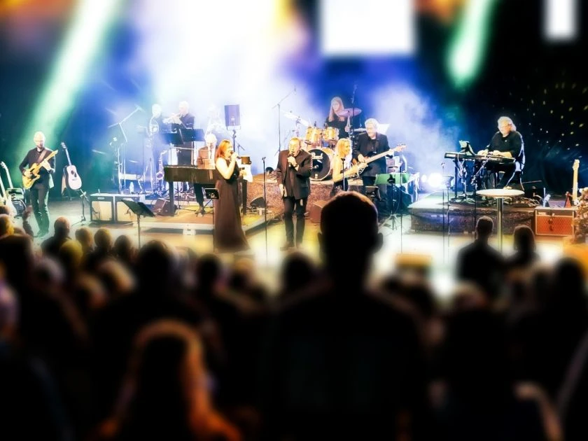 Ein Weihnachtstraum von Uwe Müller Eine Live-Band performt auf einer stimmungsvoll beleuchteten Bühne vor einem großen Publikum.