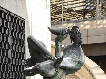 Dionysus Fountain Die Skulptur des Dionysos-Brunnens in Köln zeigt eine dynamische Figur aufrecht, mit erhobenem Trinkkelch, auf einem runden Sockel stehend.The sculpture of the Dionysus Fountain in Cologne shows a dynamic figure standing upright on a round pedestal with a raised drinking cup.