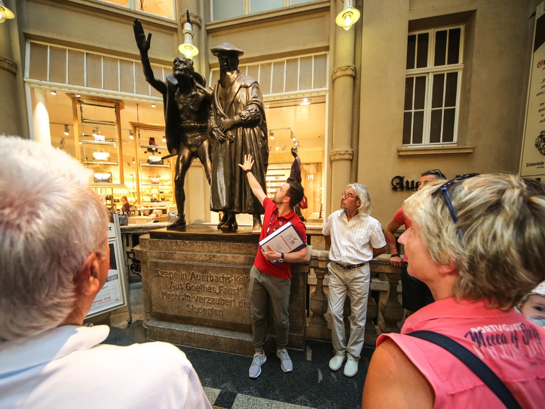 Rahmenprogramm Stadtrundgang durch die Leipziger Innenstadt | Leipzig Convention Bureau Rahmenprogramm Stadtrundgang mit Stopp einer Gruppe an der Figurengruppe am Auerbachs Keller – präsentiert vom Leipzig Convention BureauSupporting programme Guided walking tour with a group stop at the statue group at Auerbach's Cellar – presented by the Leipzig Convention Bureau