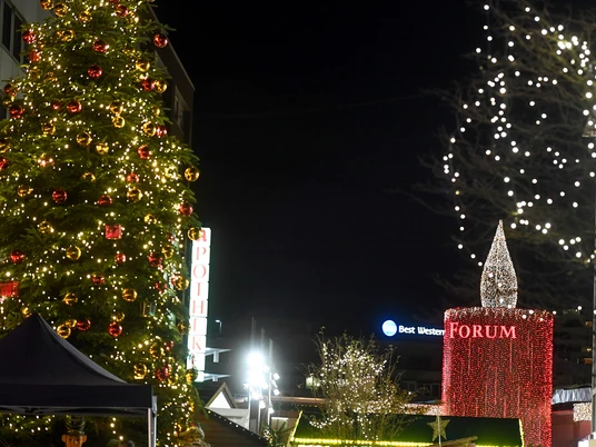 Weihnachtstreff, Mülheim an der Ruhr Ein festlich beleuchteter Weihnachtsbaum, umgeben von Lichtern, vor einem nächtlichen Stadtpanorama.