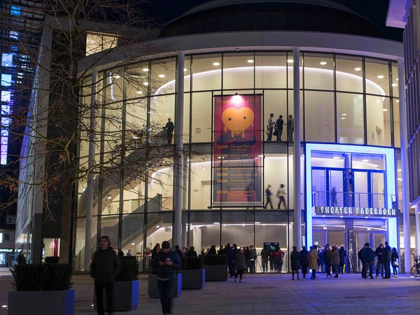 Theater Paderborn Theater Paderborn mit modernem Glasbau, abendliches Ambiente, Menschen am Eingang auf dem Vorplatz.