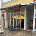 Asia Wok.jpg Das Bild zeigt einen Asia Wok Schnell-Imbiss mit Glasfronten und einem Tisch mit Stühlen davor.