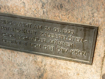 Rosa-Winkel-Mahnmal Bronzetafel mit Gravur: "Eingeweiht am 24.06.1995, Patenschaft Zauberflöten-Chor schwuler Männer, gestiftet von der ÖTV Köln."Bronze plaque with engraving: "Inaugurated on 24.06.1995, sponsorship of the Magic Flute Choir of gay men, donated by the ÖTV Cologne."