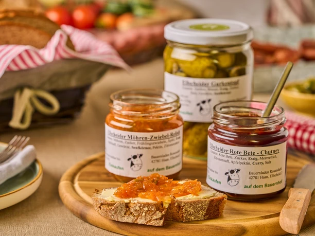 Herzhafte Aufstriche von Gut Ellscheid, Haan Verschiedene Gläser mit hausgemachten Aufstrichen und Chutneys auf einem Tisch mit rustikalem Brot.