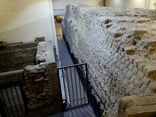 Roman city wall Die Aufnahme zeigt einen Abschnitt der antiken römischen Stadtmauer in Köln, eindrucksvoll eingebettet in eine moderne Tiefgarage. The photo shows a section of the ancient Roman city wall in Cologne, impressively embedded in a modern underground parking garage.