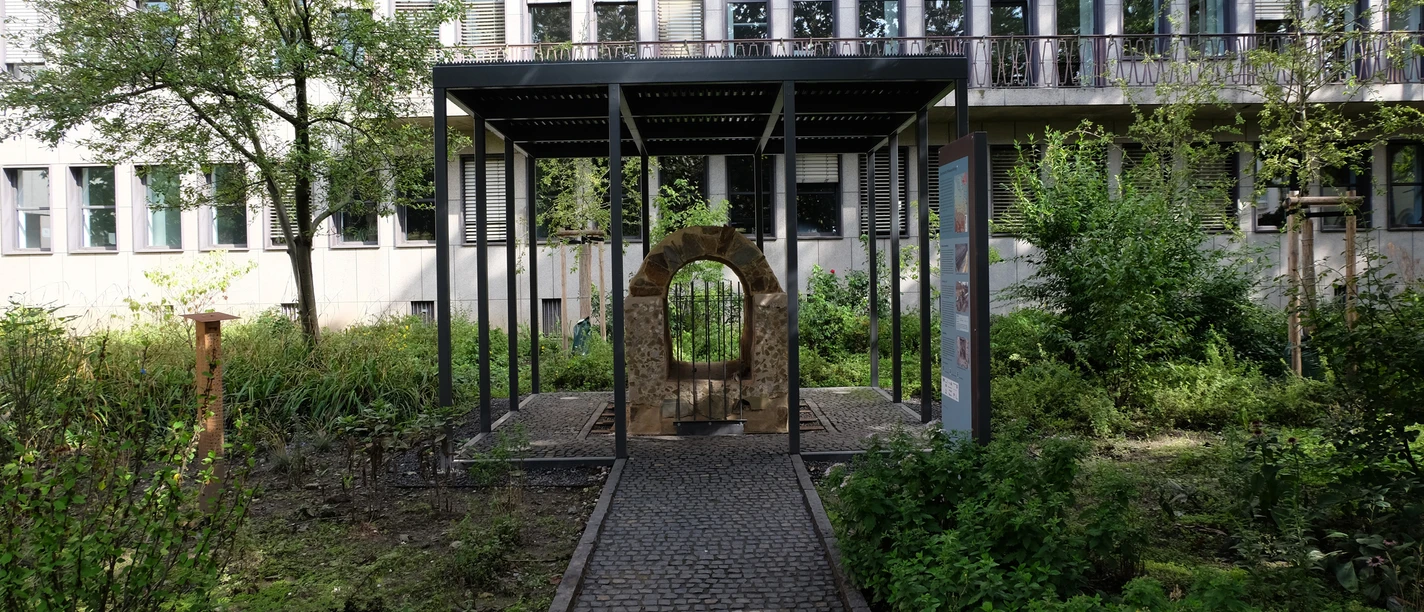 Römische Eifelwasserleitung Das Bild zeigt den Römerkanal, ein antikes Relikt mit Beschilderung, eingebettet in eine grüne Umgebung.