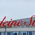 LiebedeineStadt Gebäude mit rotem Schriftzug „Liebe deine Stadt“ auf dem Dach, bewölkter Himmel im Hintergrund.