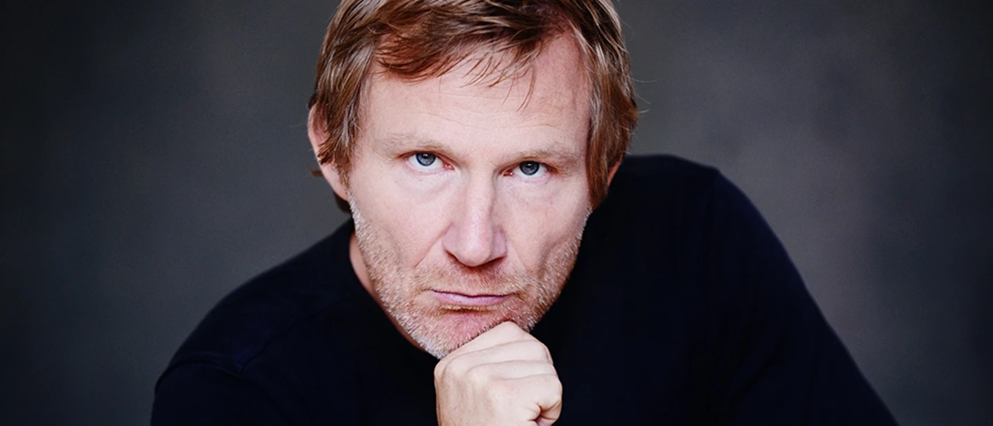 Jankowsky©MKnickriem.jpg Porträt eines nachdenklichen Mannes mittleren Alters mit verschränkten Fingern und ernstem Blick.