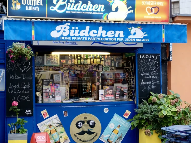 La Ola Büdchen Farbenfrohes Büdchen in Köln, dekoriert mit Bildern und Schildern. Einladender Treffpunkt.