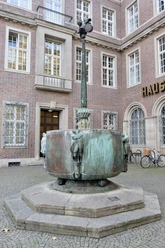 Carnival fountain Carnival fountain in front of the historic building in Cologne, with arched figures and fountain basin.