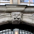 Grinkopf Steinerner Grinkopf mit kunstvoller Fratze über einem Bogen, eingerahmt von Fruchtmotiven.Stone grin head with artistic grimace above an arch, framed by fruit motifs.
