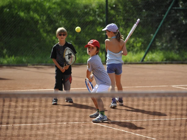 Kinder, die Tennis spielen