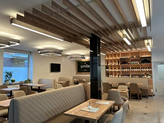 Eiscafé Smile Einrichtung Ein modernes Restaurant mit eleganten Holzakzenten, gemütlichen Sitzbänken und einer stilvollen Weinwand.