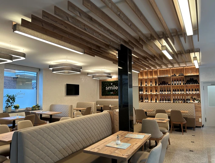 Eiscafé Smile Einrichtung Ein modernes Restaurant mit eleganten Holzakzenten, gemütlichen Sitzbänken und einer stilvollen Weinwand.
