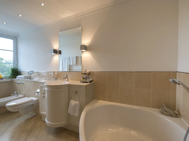 Ententurm Bad Helles Badezimmer mit Eckbadewanne, Toilette und Waschtisch. Großes Fenster sorgt für viel Tageslicht.