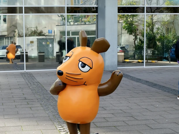 Mouse statue Life-size statue of the orange mouse from the well-known children's show stands on a sidewalk.