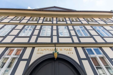Stammhaus-Mast.jpg Fachwerkhaus mit goldener Traube über dem Eingang