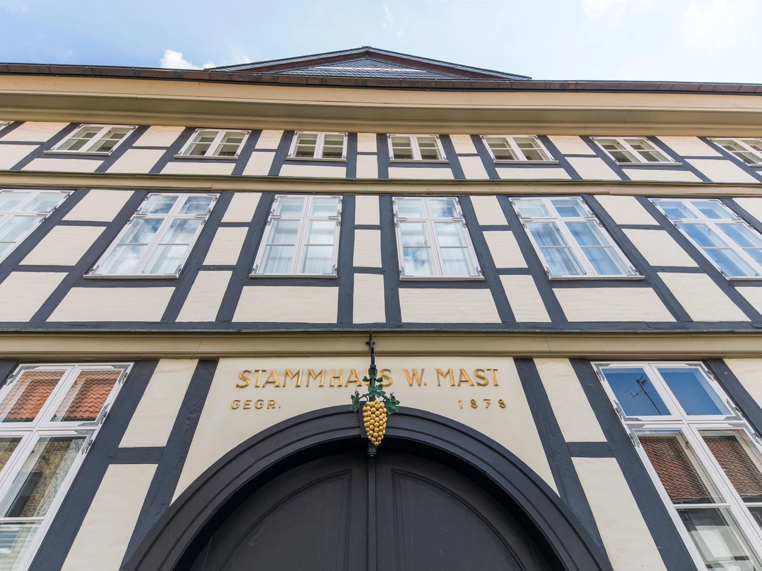 Stammhaus-Mast.jpg Fachwerkhaus mit goldener Traube über dem Eingang