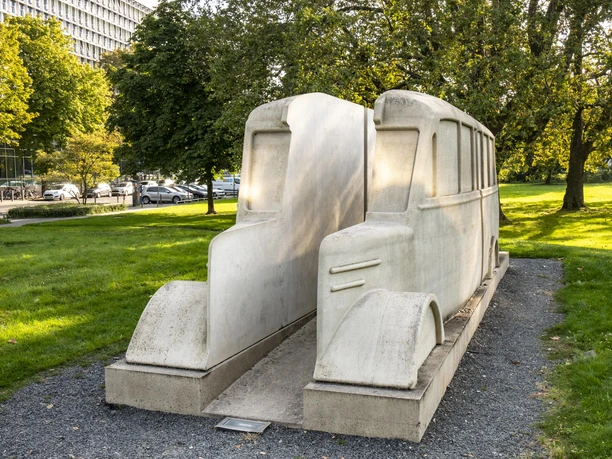 Monument to the gray buses The monument to the Grey Buses in Cologne shows two stylized stone buses on a gravel path in a green park.