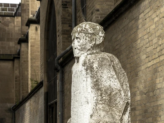 Johann Adam Schall von Bell sculpture Die Skulptur von Johann Adam Schall von Bell zeigt eine weiße Steinfigur, die mit leicht geneigtem Kopf und nach unten gerichteten Armen in einem Hof steht. Die Skulptur ist vor einer Backsteinwand platziert und strahlt eine stille Präsenz aus, die an das Erbe des Wissenschaftlers und Missionars erinnert.The sculpture by Johann Adam Schall von Bell shows a white stone figure standing in a courtyard with its head slightly tilted and arms pointing downwards. The sculpture is placed in front of a brick wall and radiates a quiet presence that recalls the legacy of the scientist and missionary.