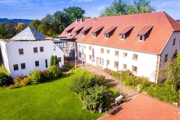 Hotel im Schlosspark_Willebadessen_Luftaufnachme _Avenarius Wohlfühlhotels.jpg Luftaufnahme eines historischen Gebäudes umgeben von gepflegten Grünflächen im Park.