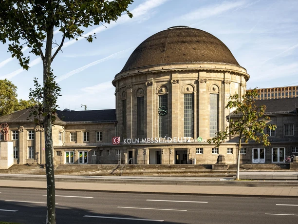 Bahnhof Köln Messe/Deutz Historischer Empfangsbereich des Bahnhofs Köln Messe/Deutz mit markantem Kuppeldach unter blauem Himmel.