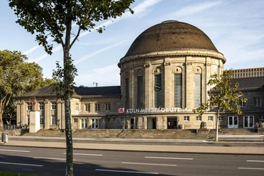 Bahnhof KoelnMesse Deutz Historischer Empfangsbereich des Bahnhofs Köln Messe/Deutz mit markantem Kuppeldach unter blauem Himmel.