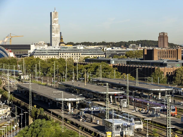 Bahnhof Köln Messe/Deutz Blick auf den Bahnhof Deutz in Köln mit Gleisen, Zügen und umliegenden Gebäuden bei Tageslicht.