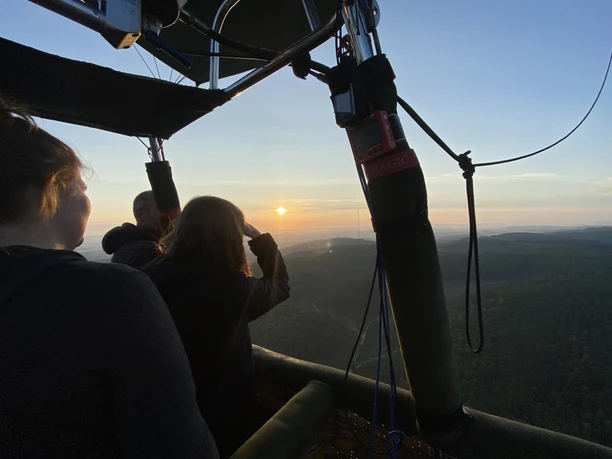Ballonfahrt_Teutoburger-Wald.jpg Menschen genießen den Sonnenuntergang während einer Ballonfahrt über dem Teutoburger Wald.