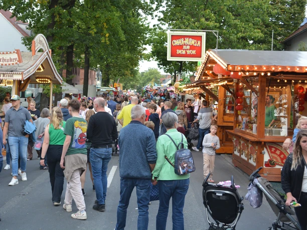 Hövelmarkt Menschen flanieren auf dem lebhaften Hövelmarkt; Verkaufsstände und fröhliche Atmosphäre prägen das Bild.