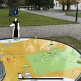 3D Landschaftsmodell Eine interaktive 3D-Landkarte mit Miniaturmodellen und Symbolen vor einem Klostergebäude.
