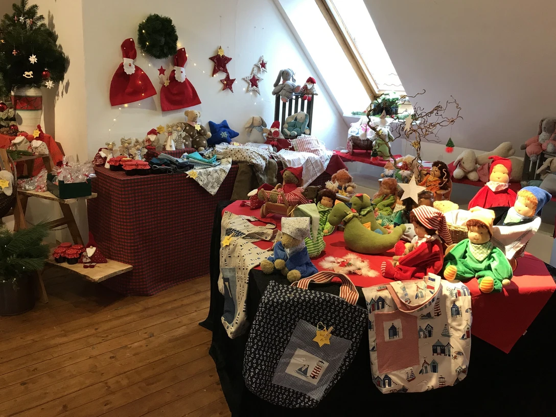 Nostalgische Weihnacht Weihnachtsdekoration und handgefertigte Puppen auf einem Holzboden in einem hellen Raum mit Dachfenster.Christmas decorations and handmade dolls on a wooden floor in a bright room with a skylight.Julepynt og håndlavede dukker på et trægulv i et lyst rum med ovenlys.Kerstversieringen en handgemaakte poppen op een houten vloer in een lichte kamer met een dakraam.