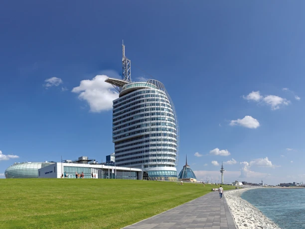 Außenansicht – ATLANTIC Hotel Sail City Modernes Hochhaus am Wasser mit gläserner Fassade, gelegen an der Promenade von Bremerhaven.