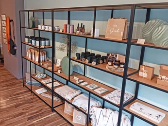 G-Werk_Deko.jpg Langes Regal mit hübsch dekorierter Ware: Textilien, Kerzen und vieles mehr