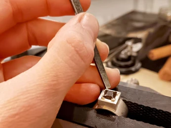 G-Werk_Handarbeit.jpg Ein Edelstein wird in einen Ring eingesetzt