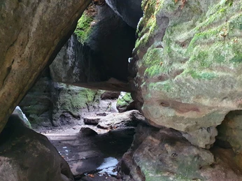 Teufelschucht Felsige Höhle mit moosbedeckten Wänden, durch die ein schmaler Pfad führt; gedämpftes Licht und ruhige Atmosphäre.Rocky cave with moss-covered walls, through which a narrow path leads; subdued light and peaceful atmosphere.Skalní jeskyně se stěnami porostlými mechem, kterou vede úzká stezka; tlumené světlo a klidná atmosféra.Skalna jaskinia z porośniętymi mchem ścianami, przez które prowadzi wąska ścieżka; stonowane światło i spokojna atmosfera.Rotsachtige grot met met mos bedekte muren, waar een smal pad doorheen leidt; gedempt licht en rustige sfeer.Grotta rocciosa con pareti ricoperte di muschio, attraverso la quale si snoda uno stretto sentiero; luce soffusa e atmosfera tranquilla.