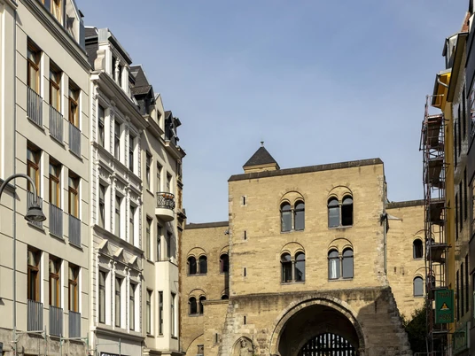 Eigelsteintorburg Die Eigelsteintorburg in Köln, flankiert von historischen Gebäuden unter blauem Himmel.The Eigelstein City Gate in Cologne, flanked by historic buildings under a blue sky.
