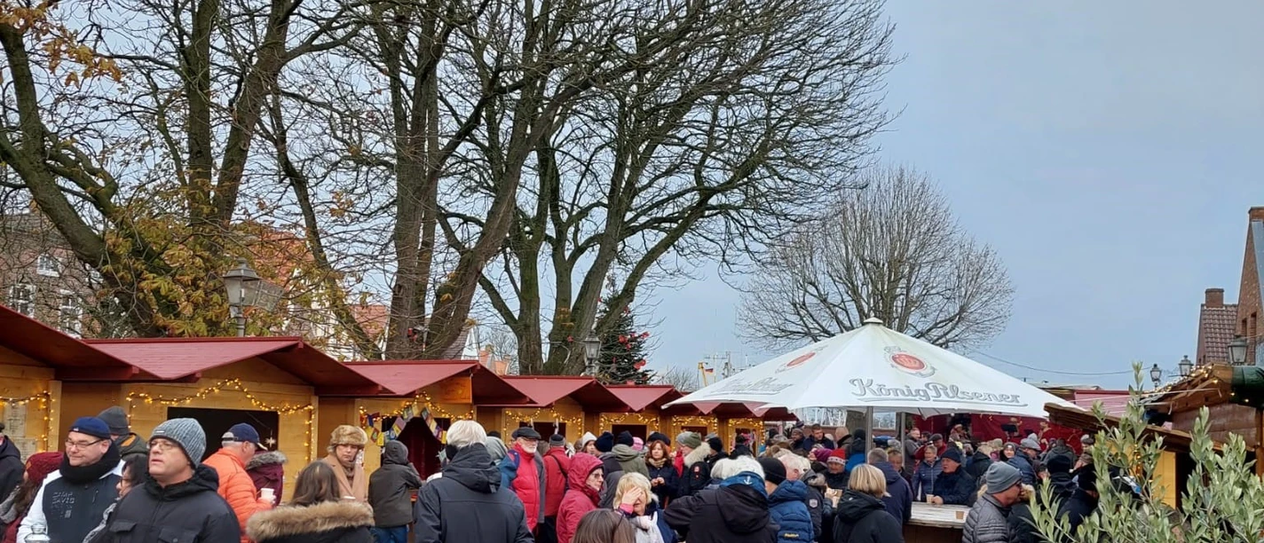Weihnachtsmarkt Greetsiel 2022 Je ziet een paar kerstkraampjes en mensen uit de verte.