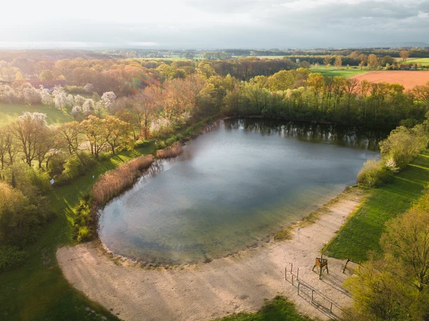 Badesee Mindenerwald Badesee im Mindenerwald, umgeben von Bäumen und Natur, mit einem sandigen Ufer und klaren Wasser.
